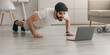 © Prostock-studio - Healthy and body care on quarantine. Training at home. Attractive 30s young arabian man doing push-ups in minimalist bedroom interior, looking at laptop on floor, near dumbbells and bottle of water