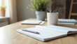 © Oleg - Office desk with open notebook and pen alongside stationery items