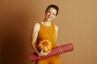 © Alliance - Smiling Fitness Woman with Yoga Mat and Fall Pumpkin