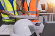 © Sirikarn Rinruesee - Closeup of team of industrial engineers meeting analyze machinery blueprints consult project on table in manufacturing factory. Working in manufacturing plant or production plant.