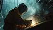 © StudioPhoto - A male welder, welds a complex structure in a factory, a specialist welder welds metal in a factory.