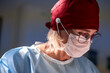 © Georgii - Focused medical professional wearing surgical mask and cap during operation