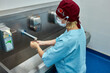 © Georgii - Healthcare professional washing hands for hygiene in a clinical environment
