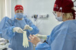 © Georgii - Healthcare professionals preparing for surgery in a medical setting