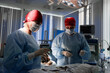 © Georgii - Medical professionals in sterile gowns performing surgery in a modern operating room