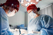 © Georgii - Surgeons collaborating in a brightly lit operating room wearing protective masks