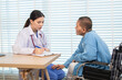 © Rakchanok - Elderly woman and caregiver or specialist nurse support kneels beside wheelchair, heartfelt conversation build trust communication while holding hands, boosting confidence recovery wellbeing in clinic