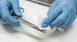 © Nurul - Closeup of a medical professional in blue gloves meticulously cleaning and sterilizing a surgical instrument with a sterile wipe