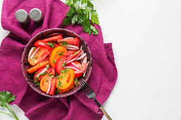 Wall Mural - Bowl of fresh tomato salad with red onion and parsley on white background