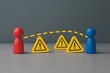© photo forest - Red and blue figures separated by warning signs; conceptual image of risk, communication breakdown, and conflict resolution.