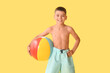 © Pixel-Shot - Cute little boy with beach ball on yellow background