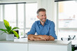 © Westend61 - Confident businessman smiling in modern office setting