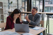 © Tj - Business people working together, senior manager scolding young businesswoman in office meeting, employee getting headache from being reprimanded by boss