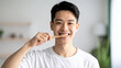 © photostockatinat - A smiling person brushing their teeth with a bamboo toothbrush, promoting oral hygiene and a healthy lifestyle.