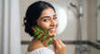 © PRASANNAPIX - young indian woman in elegant holds a green leaf near her face
