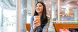 Asian freelance woman enjoying premium coffee drink in cozy cafe, casual workday lifestyle, delivery coffee, cafe trend, relaxing after shopping, modern urban working culture for young professionals