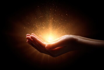 two cupped hands hold a burst of radiant light with golden particles against a deep black background