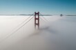 Aerial black and white photograph of a renowned suspension bridge enveloped in summer mist