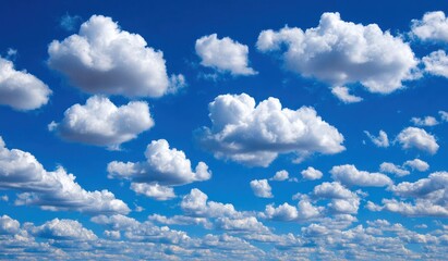 Wall Mural - Fluffy white clouds drift lazily across a bright, saturated blue sky, creating a serene and peaceful atmosphere
