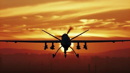 Wall Mural - A military plane flies in the sky as the sun sets behind it, with a orange and pink hue in the background