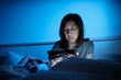 © tigercat_lpg - Asian single mum is sleepless, using mobile phone before sleep, social media addiction, insomnia all night near a daughter in bedroom, mature and menopausal woman, widow middle-aged mother lifestyle.