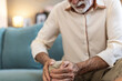 © Jelena Stanojkovic - Senior man, knee pain and arthritis on couch with home, leg massage and joint problem with gout. Sofa, mature person and bone inflammation with rheumatism, crisis and living room with strain injury.