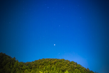 Wall Mural - Stars begin to appear in the blue sky of early evening.