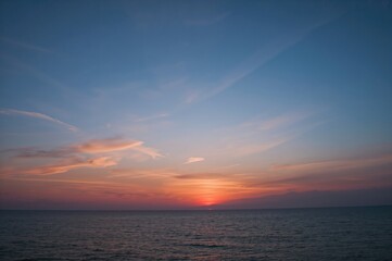 Wall Mural - Stunning sunrise or sunset with vibrant blue and orange hues over the ocean