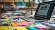 © Ada - vibrant, messy desk in a creative office. The desk is filled with colorful sticky notes, sketchbooks, pens, and a laptop displaying a design mockup. The background is blurred, focusing on the details