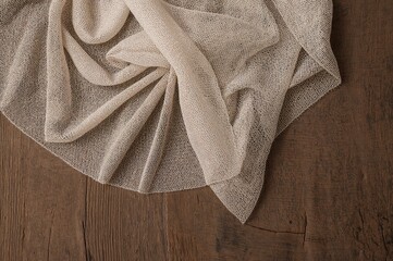 Wall Mural - Delicate mesh lace fabric spread over a rustic wooden surface, showcasing intricate texture and elegant draping