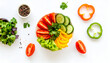 © ArtNote - A vibrant overhead view of a colorful bowl of fresh, sliced vegetables and herbs, artfully arranged.