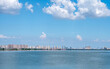 Tangxun Lake shows a city skyline with buildings under a blue sky and clouds.