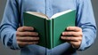 © afridwi - Person holding open green book reading knowledge