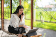 © Apichat - woman is sitting on a chair and talking on her cell phone