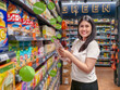 © Apichat - woman is smiling in a grocery store aisle