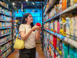 © Apichat - woman is shopping in a store and is holding a red container