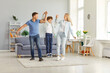 © Studio Romantic - Happy friendly family fun, playful funny parents, child having joy together with little son in modern living room, dad and mother with cute boy doing exercises, enjoying holiday, weekend at home