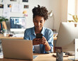 © Ranta Images - Young African American black woman working on laptop and mobile phone