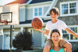 © Louis-Paul Photo - portrait of a boy kid playing with a basketball in front of house with mother