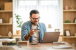 © Miljan Živković - Entrepreneur paying online with credit card on laptop at home