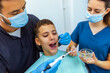 © Mediteraneo - Two Dentists Treating Boy’s Teeth with Drill Extension in Clinic