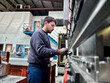 © Ivi - Powerlightss - Metalworker operating bending machine in factory