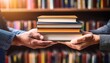 © Leanne - close up of hands passing a stack of books against a blurred bookshelf background symbolizing knowledge sharing and book exchange