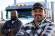 © Zembeco - Hispanic and African American truck drivers unite in front of their semi-truck.