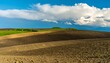 © Zhun - Rolling hills of farmland under a partly cloudy sky