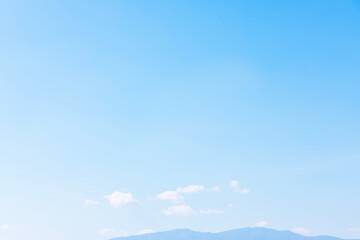 Wall Mural - blue sky background and white clouds soft focus with mountain and copy space horizontal shape.