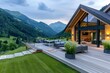 © kardaska - Modern wooden chalet with large terrace overlooking mountain valley at sunset