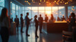 © Dmytriy - A blurred image of people at a corporate event with a sunset view through large windows