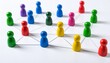 © Innovative - Multicolored pawns connected by lines on white surface, symbolizing social network