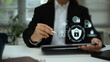 © Prathankarnpap - Businesswoman using digital tablet with holographic cybersecurity icons, data protection concept